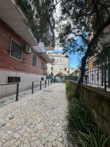 une passerelle en pierre à côté d'un bâtiment avec un arbre dans l'établissement MG Luxury Home, à Naples