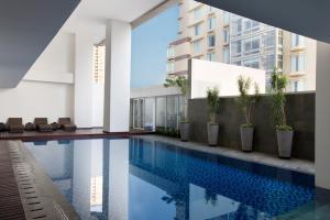 a swimming pool in the middle of a building at Hotel Santika Premiere Hayam Wuruk Jakarta in Jakarta