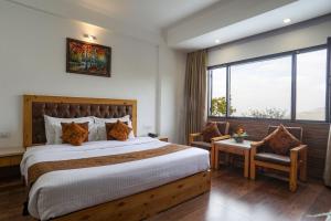 a bedroom with a large bed and a large window at The Mountain Quail in Mussoorie