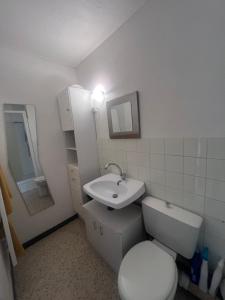 a bathroom with a white toilet and a sink at Les Appartements De Lina - West city 2 - Self Check-In - in La Grande Motte