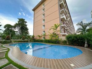 a swimming pool in front of a tall building at 2 BR Condo at Camella Manors Palawan in Puerto Princesa City +4 photos