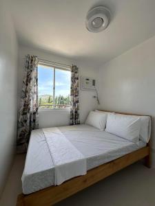 a bedroom with a large bed with a window at 2 BR Condo at Camella Manors Palawan in Puerto Princesa City