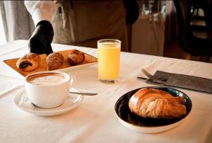 a table with a cup of coffee and a plate of pastries at HOTEL AVENIDA 22 Sector de las clinicas in Santa Marta