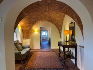 un arco en una sala de estar con sofá y mesa en Hotel Villa Sermolli, en Borgo a Buggiano