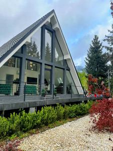 una casa con una gran ventana en el lateral en Pine Hill Poiana Marului, en Poiana Mărului