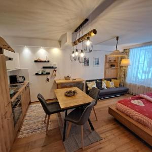 a kitchen and living room with a table and a couch at Appartement mit Hallenbad in Sankt Martin bei Lofer
