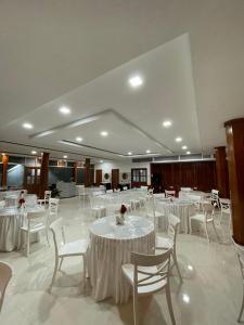 um salão de banquetes com mesas brancas e cadeiras brancas em 2K HOTEL em Kohīma
