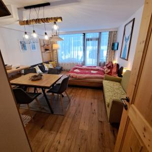 a living room with a table and a bedroom at Appartement mit Hallenbad in Sankt Martin bei Lofer