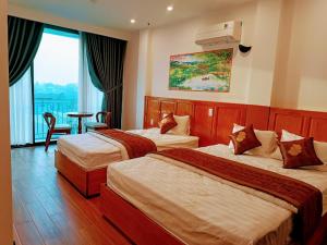 ein Hotelzimmer mit 2 Betten und einem Fenster in der Unterkunft PHƯƠNG ĐÔNG HUẾ HOMESTAY in Hue