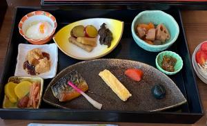 由布市にある湯布院 おやど花の湯yufuin oyado hananoyuのテーブルの上に様々な種類の食料を詰めたトレイ
