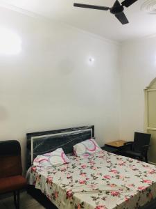a bedroom with a bed and a ceiling fan at Anavrin home stay in Muzaffarnagar