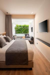 una camera con un grande letto e una TV a parete di Evanik Chic Hotel a Calimno (Kalymnos)