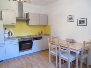 a kitchen with a wooden table and a kitchen with white cabinets at Ferienhaus Deller in Pinkafeld