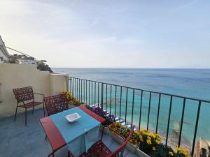 uma mesa e cadeiras numa varanda com vista para o oceano em La Bomboniera em Capri