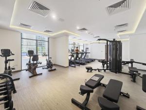 un gimnasio con varias cintas de correr y bicicletas estáticas en Stylish Studio in New residence with pool and gym en Dubái