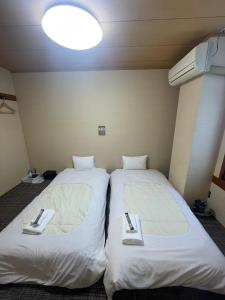 two beds sitting next to each other in a room at KOMOREBI HOSTEL-your cozy place- in Takayama