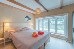 ein Schlafzimmer mit einem Bett mit zwei orangenen Kissen darauf in der Unterkunft Les Gites Kangourou Dinant in Dinant
