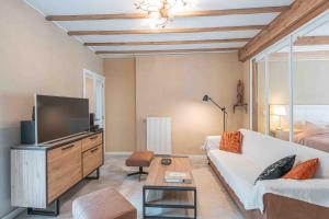 a living room with a white couch and a tv at Les Gites Kangourou Dinant in Dinant