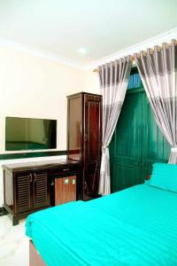 una camera con letto blu e cassettiera di Mi Linh Hotel a Nha Trang
