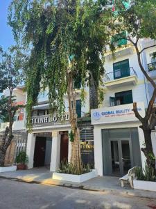 un edificio con un albero di fronte di Mi Linh Hotel a Nha Trang