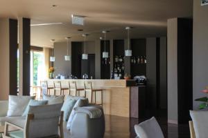 - un bar dans une salle avec des chaises et un comptoir dans l'établissement Vale d'Azenha Hotel Rural & Residences, à Alcobaça