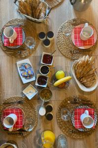 une table remplie de paniers de nourriture et de pain dans l'établissement Chambre d'Hôtes les 3 Cochons d'Olt, à Arcambal