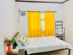 a bedroom with a bed and a yellow curtain at Masayay Homestay With Starlink Wifi in Santa Monica
