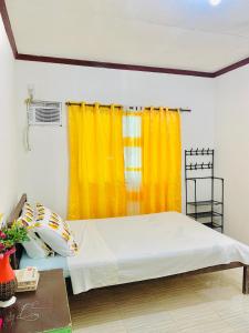 łóżko w pokoju z żółtymi zasłonami w obiekcie Masayay Homestay With Starlink Wifi w mieście Santa Monica