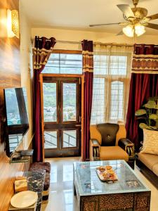 a living room with a couch and a table at Kavi's Vacation Homes - Peaceful stay in sainj valley in Sainj