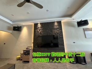 a living room with a flat screen tv on a wall at 尹居 包棟民宿 in Xiaoliuqiu