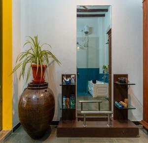 a bathroom with a large vase with a plant in it at Luigi Villa in Puducherry