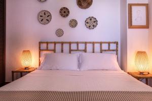 a bedroom with a bed with two lamps and plates on the wall at Villa Federica: Natura e Mare in Torre delle Stelle