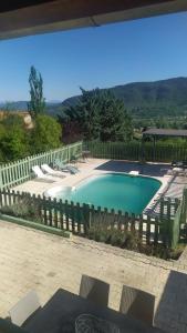 uma grande piscina com cerca e cadeiras em Maison de 2 chambres avec piscine privee et jardin clos a Veyras em Veyras