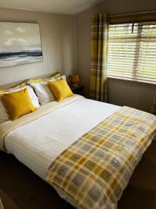 a bedroom with a large bed with yellow pillows at Sandy Bay Caravan Getaway in Newbiggin-by-the-Sea