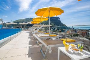 una fila de mesas con sombrillas amarillas en el techo en Sky Pool Hotel Sole Garda en Garda