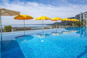 a swimming pool with umbrellas on top of a building at Sky Pool Hotel Sole Garda in Garda