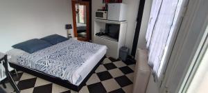 Dormitorio pequeño con cama y TV en Chambre privative à st remy en mauges, en La Chaussaire
