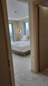 a bedroom with a bed in a room with marble floors at AIR-IN Rooms with magnificent views in Artemida