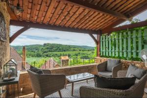 an outdoor patio with chairs and a view of the mountains at Le Coin Tranquille in La Roque-Gageac