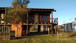 une maison avec un porche et un balcon dans l'établissement Cabañas El Ocio, à Punta del Diablo