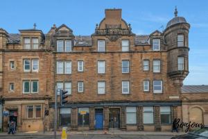 an old brick building on the corner of a street at Lilas Suite Abbeyhill - 1BR-1BA 5 Mins to Meadowbank Shopping by Bonjour Residences Edinburgh in Edinburgh