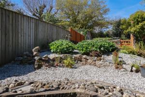 un jardín con rocas y plantas frente a una valla en Eden Retreat en Par