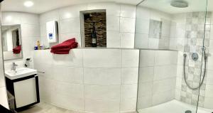 a white bathroom with a shower and a sink at Das besondere Moselhaus-Mosel ultranah Luxus Ferienhaus Mosel in Kinheim +42 photos
