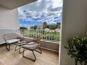 a balcony with two chairs and a table at Saint Cyprien, superbe appartement calme proche du port, parking in Saint-Cyprien +6 photos
