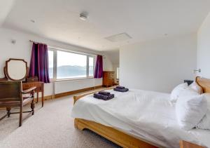 a bedroom with a bed and a desk and a mirror at Cyfannedd Uchaf in Fairbourne