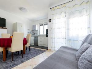 a living room with a dining table and a kitchen at Simplistic Apartment in Malinska near the Sea in Malinska