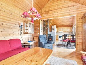 - un salon avec un canapé rouge et une table dans l'établissement 6 person holiday home in nneland, à Ånneland