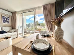a living room with a table with a vase on it at Saint Cyprien, superbe appartement calme proche du port, parking in Saint-Cyprien