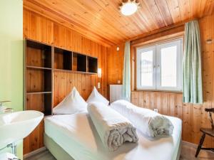 a bedroom with two beds and a sink and a window at Holiday home in the Silvretta-Montafon ski area in Sankt Gallenkirch