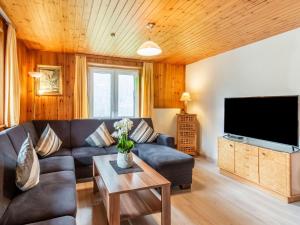 a living room with a couch and a flat screen tv at Chalet in Montafon near Ski Lifts in Sankt Gallenkirch